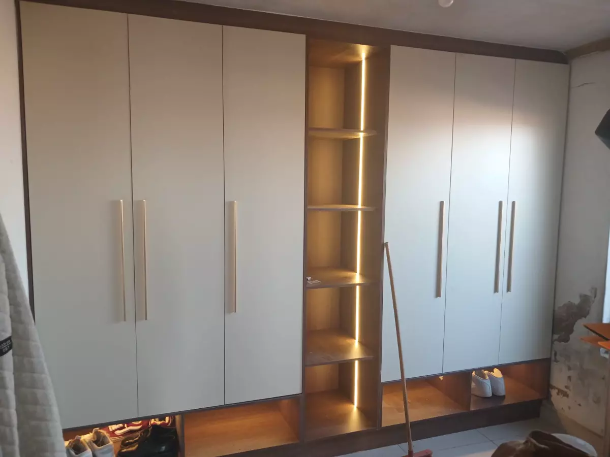 Built-in wardrobe with illuminated central shelving