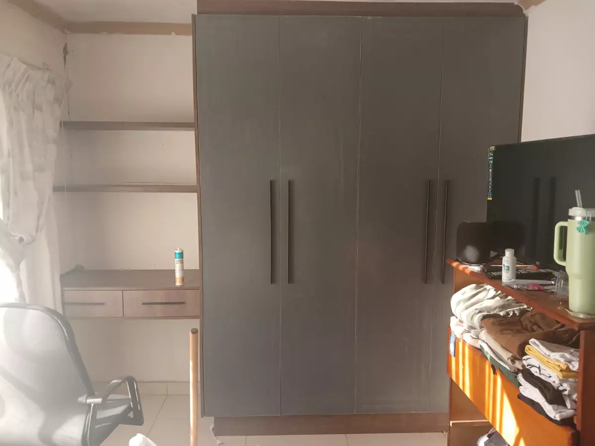 Large dark grey fitted wardrobe with built-in desk and shelving